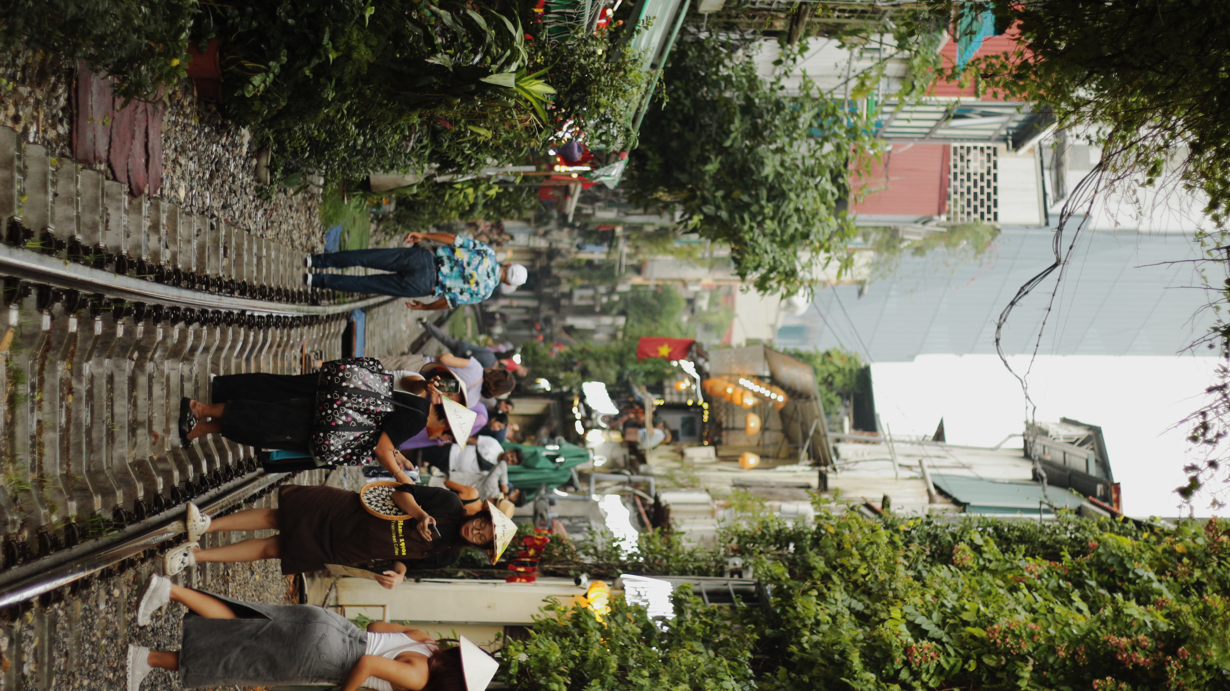 Hanoi Train Street with people walking on the train track